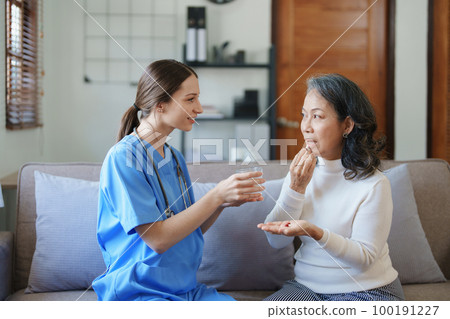 Portrait of a female doctor giving medicine to an elderly patient Portrait of a female doctor giving medicine to an elderly patient 100191227