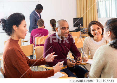 Multiethnic group of young people studying together at table Multiethnic group of young people studying together at table 100197235