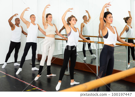 people doing exercises on stretching ballet barre 100197447