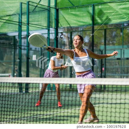 Padel game - woman with partners plays on tennis court Padel game - woman with partners plays on tennis court 100197628