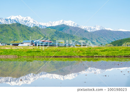 從大町市看到的北阿爾卑斯、後立山連峰和特急梓（5月） 100198023