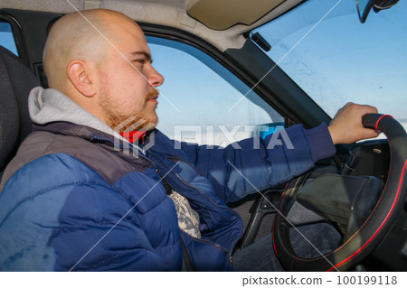 Young man driving a car on winter road. Inside view Young man driving a car on winter road. Inside view 100199118