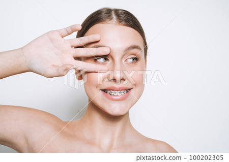 Funny young girl with fresh skin, teenager with braces on teeth on white background isolated Funny young girl with fresh skin, teenager with braces on teeth on white background isolated 100202305