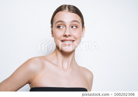 Young girl with fresh skin, teenager with braces on teeth on white background isolated Young girl with fresh skin, teenager with braces on teeth on white background isolated 100202306