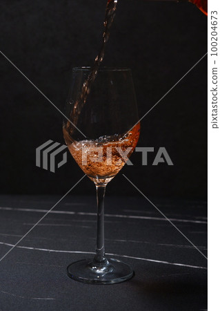 將桃紅葡萄酒倒入酒杯中 100204673