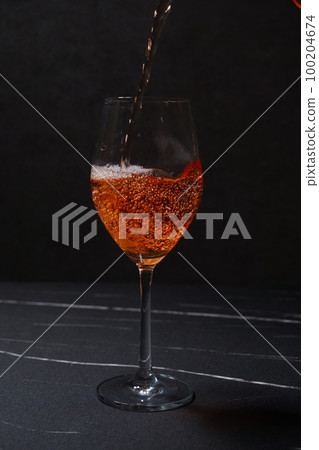 將桃紅葡萄酒倒入酒杯中 將桃紅葡萄酒倒入酒杯中 100204674