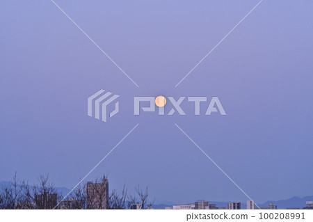 Full moon setting over a city in the Tama region 100208991