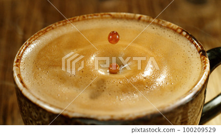 Detail of pouring whiskey into glass with ice cubes. Detail of pouring whiskey into glass with ice cubes. 100209529