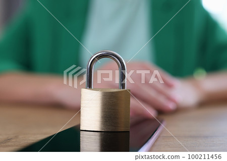 Smartphone with padlock on table and business woman in background. Smartphone with padlock on table and business woman in background. 100211456