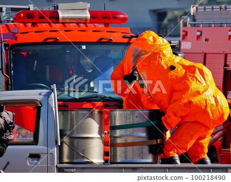 A firefighter wearing a chemical protective suit and working 100218490