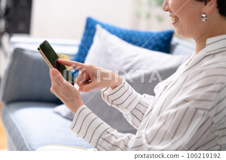 手邊的智能手機卡支付高級女性 100219192