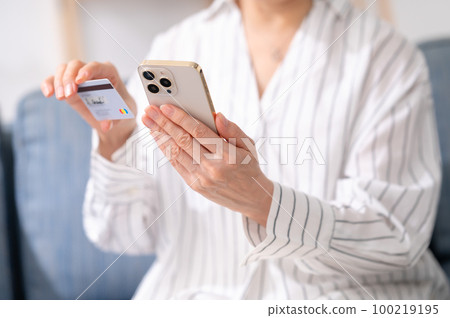 Smartphone card payment senior woman at hand 100219195