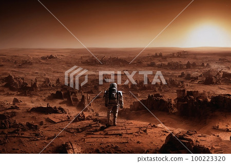 Astronaut stands on the edge of cliff. Mars exploration. Back view of astronaut in space suit walking on a mars. Ancient alien ruins In the distance 100223320