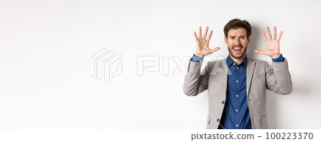 Frustrated man giving up, raising hands up in surrender and screaming, having argument, wearing suit and looking distressed, white background 100223370