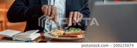 Close up of businessman taking a breakfast before starting working day in cafe 100225074