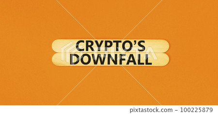 Crypto downfall symbol. Concept words Cryptos downfall on wooden stick. Beautiful orange table orange background. Business and crypto downfall concept. Copy space. 100225879
