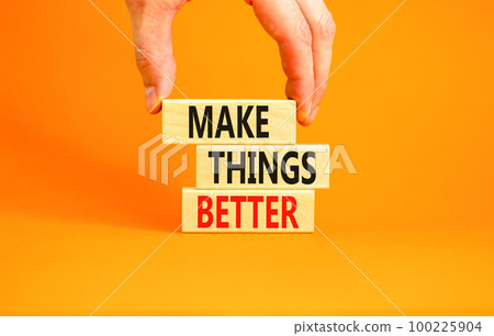 Make things better symbol. Concept words Make things better on wooden block on a beautiful orange table orange background. Businessman hand. Business and make things better concept. Copy space. 100225904