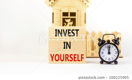 Invest in yourself symbol. Concept words Invest in yourself on wooden block on a beautiful white table white background. Black alarm clock. Business and Invest in yourself concept. Copy space. 100225905