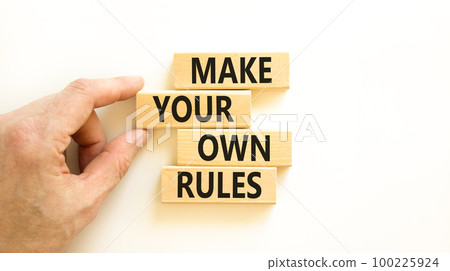 Make your own rules symbol. Concept words Make your own rules on wooden cubes. Beautiful white table white background. Businessman hand. Business motivational make your own rules concept. Copy space 100225924