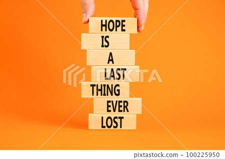 Do not lost hope symbol. Concept words Hope is a last thing ever lost on wooden blocks on a beautiful orange background. Businessman hand. Business motivational and do not lost hope concept. Do not lost hope symbol. Concept words Hope is a last thing ever lost on wooden blocks on a beautiful orange background. Businessman hand. Business motivational and do not lost hope concept. 100225950