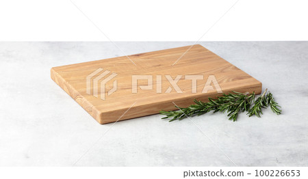 Cutting board and rosemary on a grey stone table. 100226653