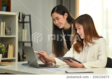 Smiling business coworkers are collaborating, brainstorming over new marketing during corporate meeting Smiling business coworkers are collaborating, brainstorming over new marketing during corporate meeting 100226873
