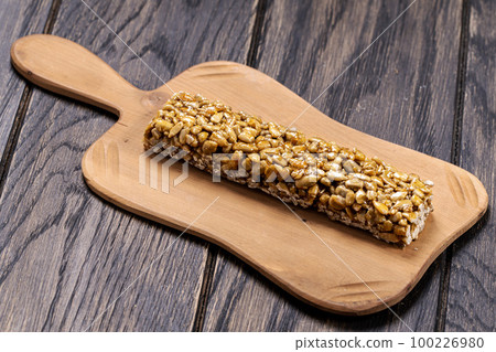 Sweet kozinaki bar from sunflower seeds on platter 100226980