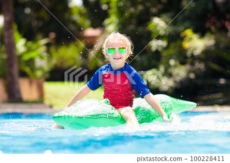 Child in swimming pool. Kid on inflatable float Child in swimming pool. Kid on inflatable float 100228411