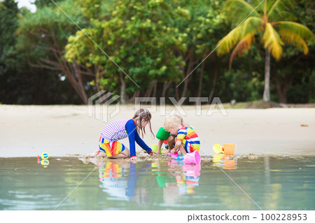 Kids on tropical beach. Children playing at sea. 100228953
