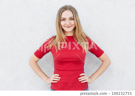 Portrait of young woman with wonderful hair having delightful expression wearing red dress. Smiling pretty female with dimples on cheeks being happy to pose in studio. Beauty and youth concept 100232755