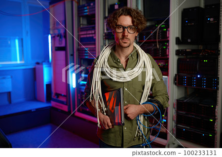 Portrait of signalman with many wires on shoulders and laptop in hand Portrait of signalman with many wires on shoulders and laptop in hand 100233131