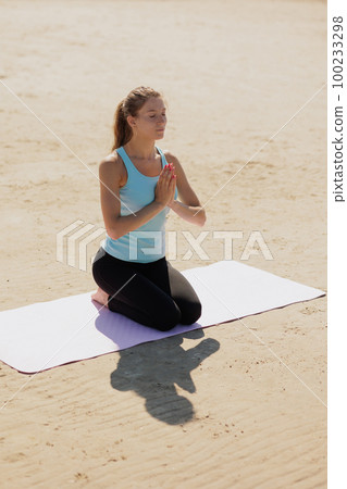 yoga, woman do meditation on seashore in morning. fitness millennial female trains 100233298