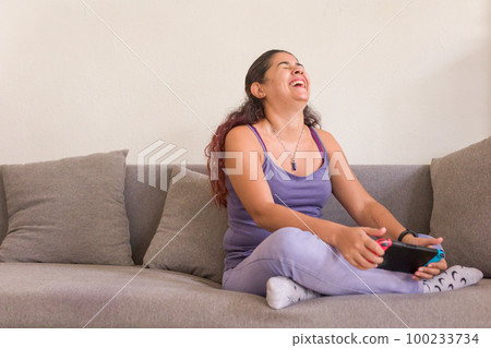 Latin woman playing happy game portable console. generation z gamer with controller. venezuelan mid 100233734