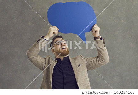 Happy young man holding a speech balloon sharing his thoughts and business ideas Happy young man holding a speech balloon sharing his thoughts and business ideas 100234165