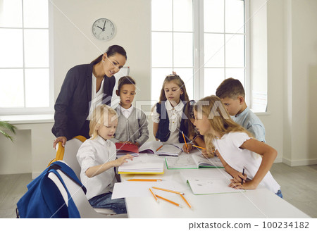 Group of elementary school students with teacher drawing pictures in the classroom 100234182