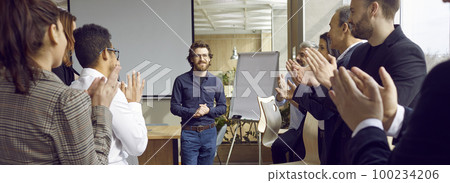 Group of people are greeting man coach in modern office clapping hands, adult aducation concept. 100234206