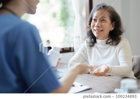 Portrait of a female doctor giving medicine to an elderly patient Portrait of a female doctor giving medicine to an elderly patient 100234893