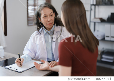 Portrait of a female doctor using a stethoscope to check the pulse of an elderly patient Portrait of a female doctor using a stethoscope to check the pulse of an elderly patient 100235071