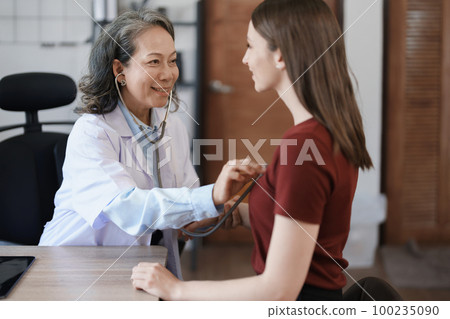 Portrait of a female doctor using a stethoscope to check the pulse of an elderly patient Portrait of a female doctor using a stethoscope to check the pulse of an elderly patient 100235090