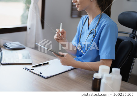 Portrait of a female doctor using a tablet computer and a document analyzing a patient's condition before treating Portrait of a female doctor using a tablet computer and a document analyzing a patient's condition before treating 100235105