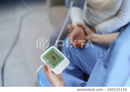 Portrait of female doctor measuring patient's blood pressure before treatment 100235136