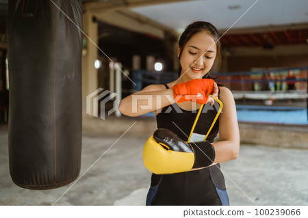 a beautiful boxer wearing the boxing gloves at her left hand a beautiful boxer wearing the boxing gloves at her left hand 100239066