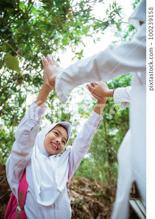 two female elementary students playing together happily two female elementary students playing together happily 100239158