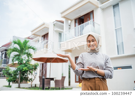 attractive Asian woman in hijab with hand gesture presenting attractive Asian woman in hijab with hand gesture presenting 100239447