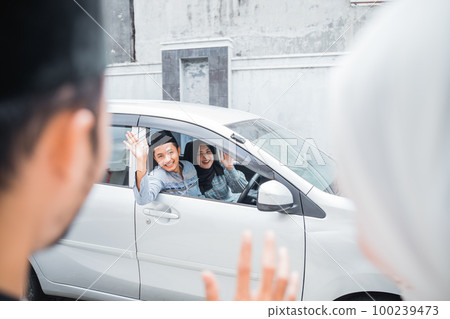 Asian Muslim couple meet by waving from car window 100239473