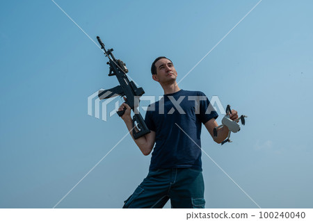 Caucasian man shot down a drone with a shot from a rifle.  100240040