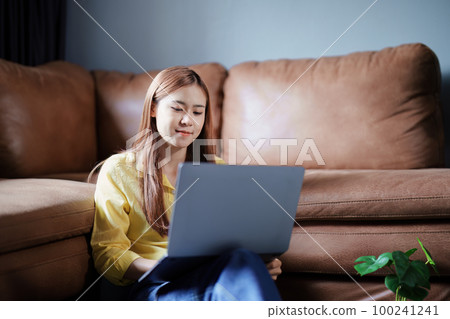 Portrait of a beautiful Asian teenage girl using a computer. Portrait of a beautiful Asian teenage girl using a computer. 100241241