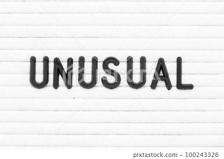 Black color letter in word unusual on white felt board background 100243326