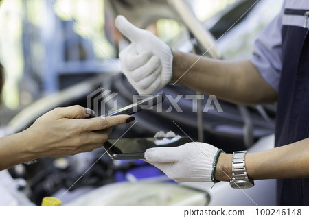 Asian women get contact numbers from Asian male auto mechanics after fixing the car engine problem and QR code scan to pay for fixing vehicle service. Car repair, and maintenance concept. Asian women get contact numbers from Asian male auto mechanics after fixing the car engine problem and QR code scan to pay for fixing vehicle service. Car repair, and maintenance concept. 100246148