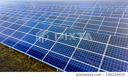 Aerial drone view flight over solar power station panels. Aerial top view of solar farm. Green energy, electrical innovation. Renewable Energy. Industrial Solar Energy Farm producing solar power. 100250433